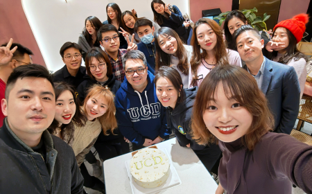 A group of UCD alumni at a global event, posing for a photo.